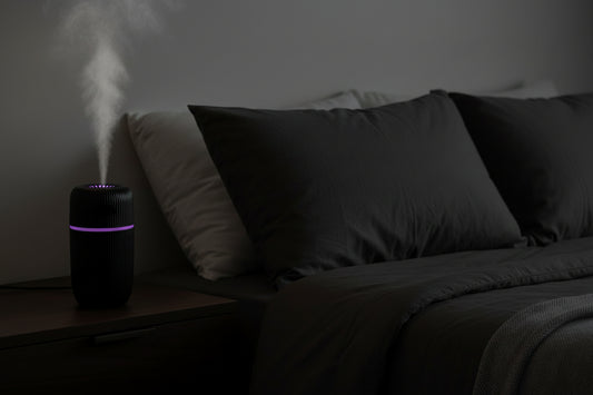 Black and white humidifiers on a wooden surface with a decorative frame and books in the background.